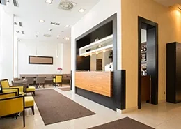 A clean, modern hotel lobby with a reception desk and seating.